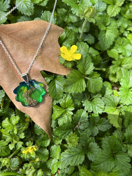 Concha Presente apoyada en una hoja sobre un manto de hojas verdes del camino de Santiago. Un regalo perfecto para ese peregrino que sintió el camino en lo mas hondo de su ser. 